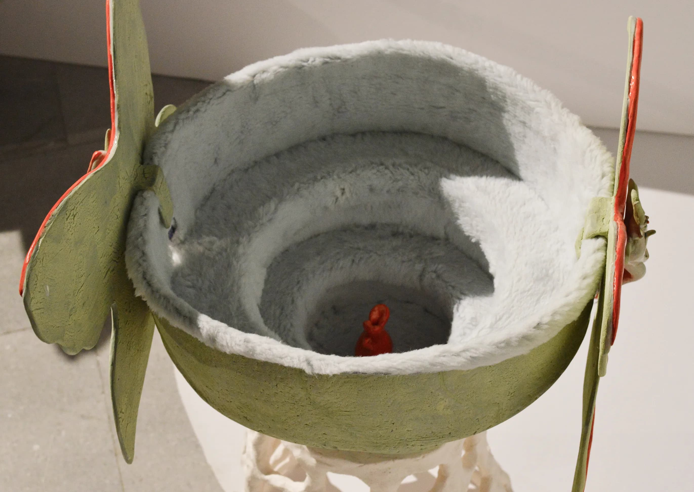Detail of a glazed ceramic bowl displayed on a plinth