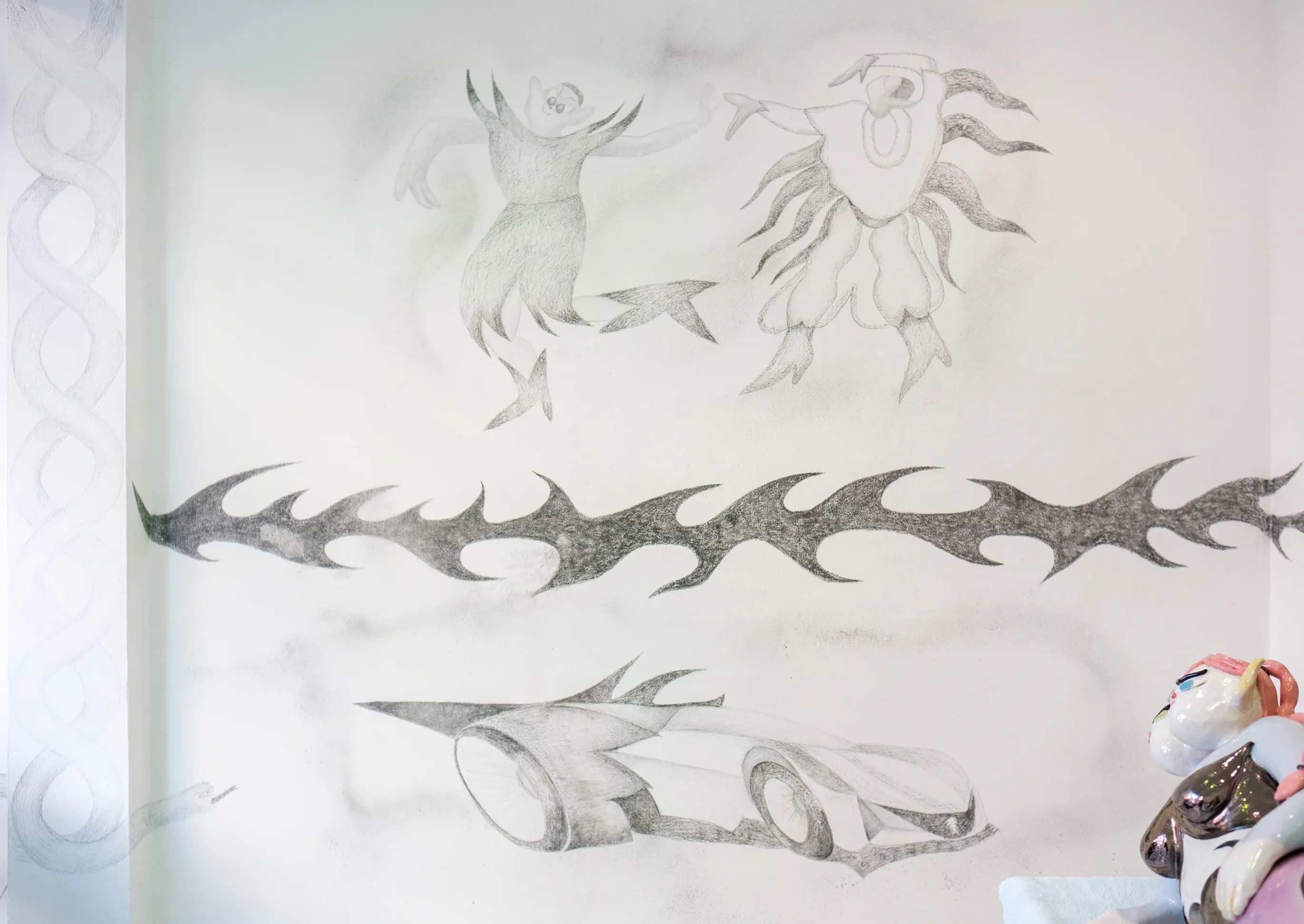 Pencil wall drawings of dancing masked figures, a thorn vine, and a sports car
