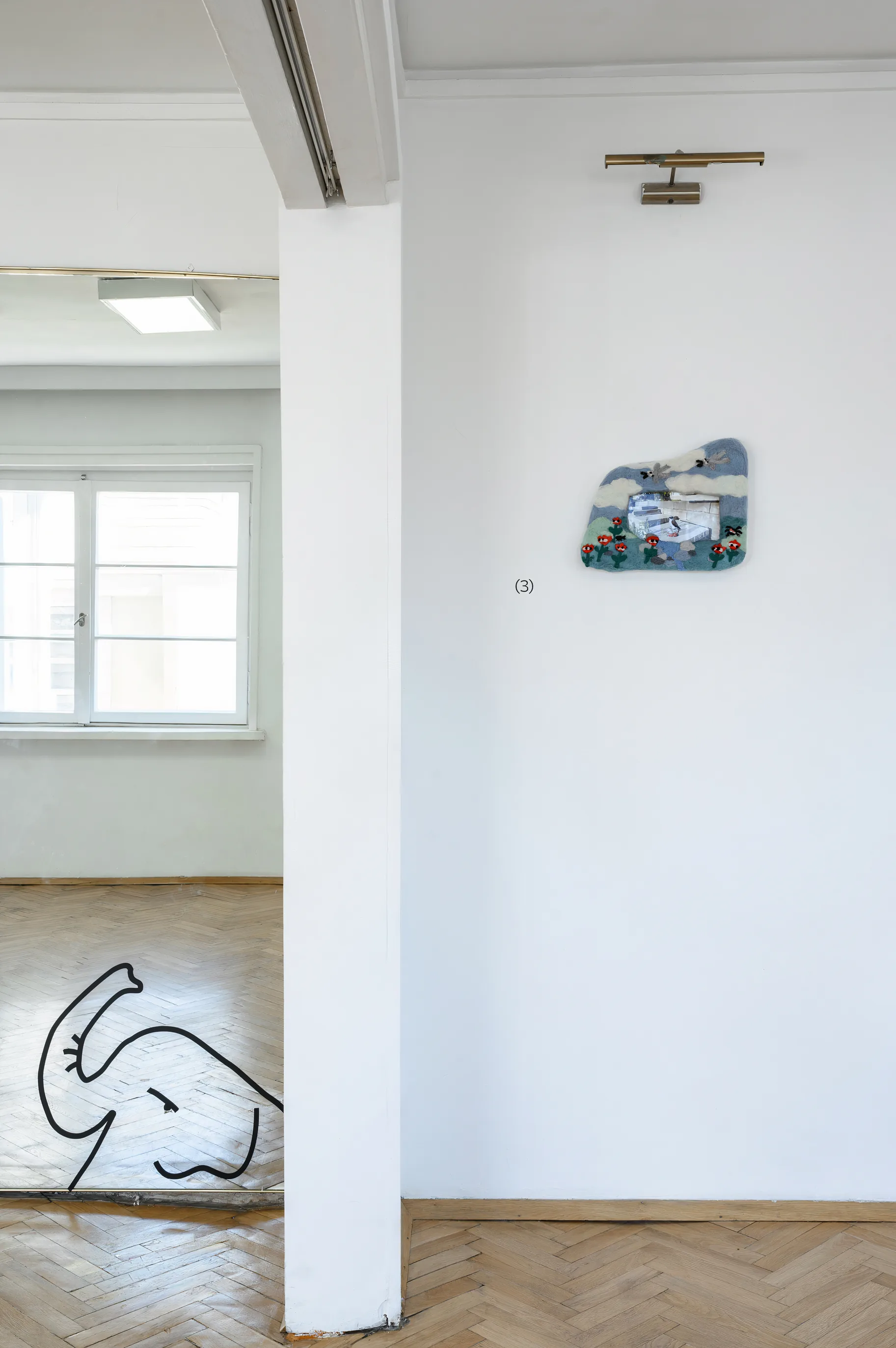 Installation view of the felted wall relief on a white wall, with a drawing of an elephant on the floor