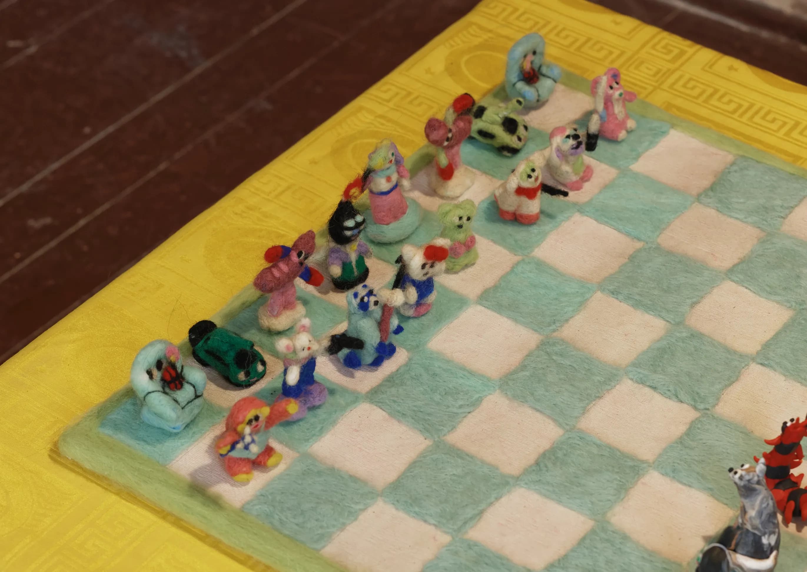 Detail of hand-sculpted clay figures standing in as chess pieces on a felt board